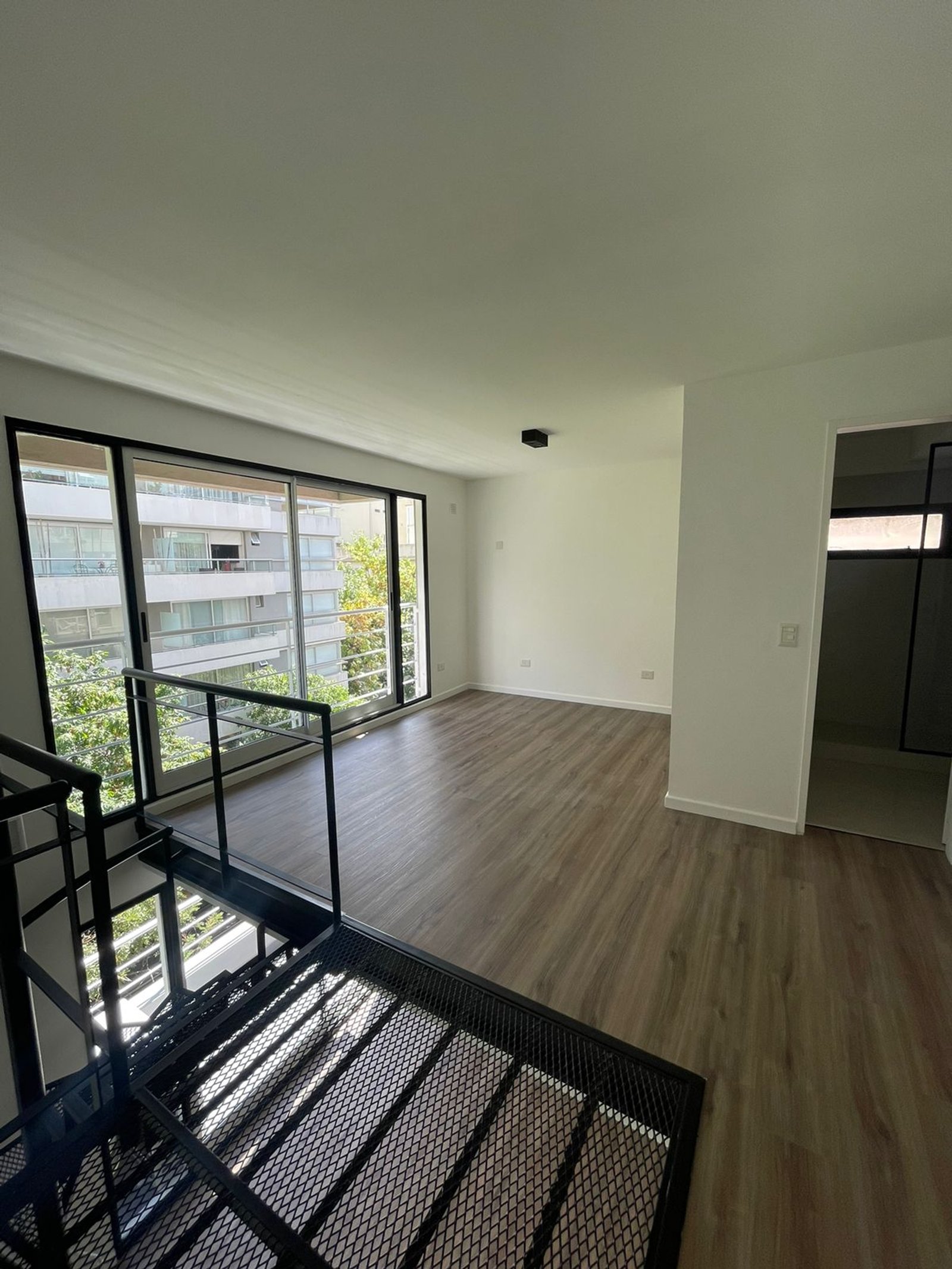 Escada flutuante moderna em loft com vista urbana — projeto Jorge Newbery, por Estudio NET Arquitectura, em Av. Jorge Newbery 1820